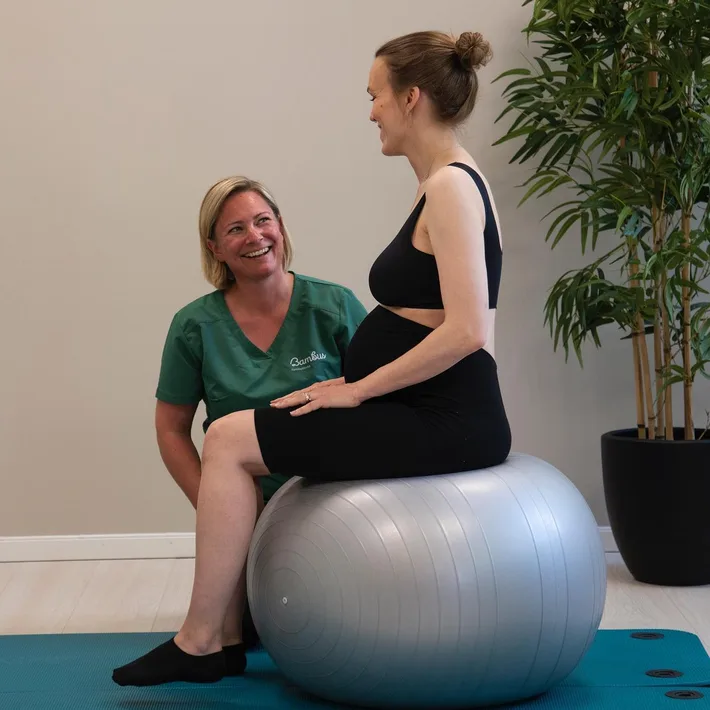 En fysioterapeut veileder en gravid person